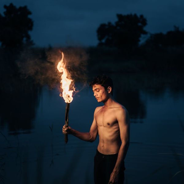 Silhouette of a man stretching against a serene, dark background.